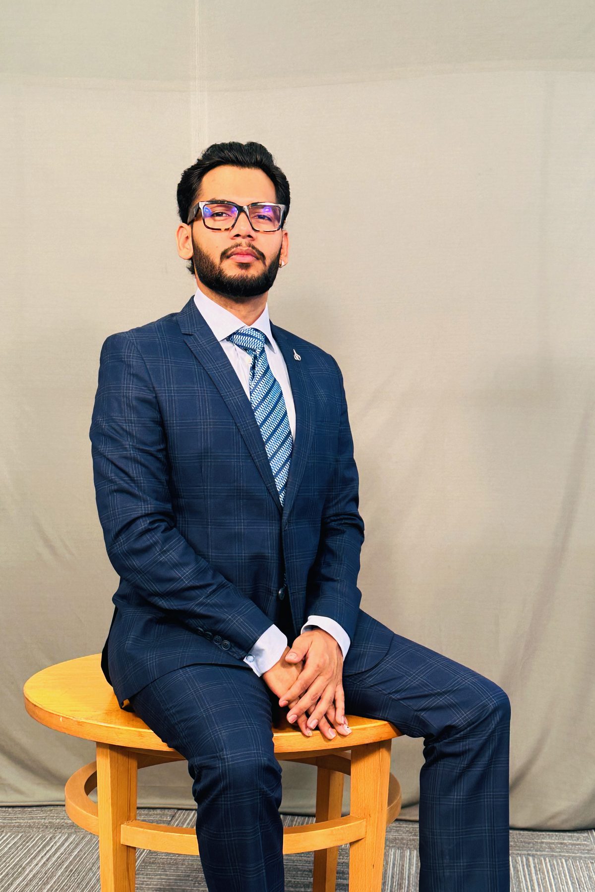 Harsh in a navy suit, seated