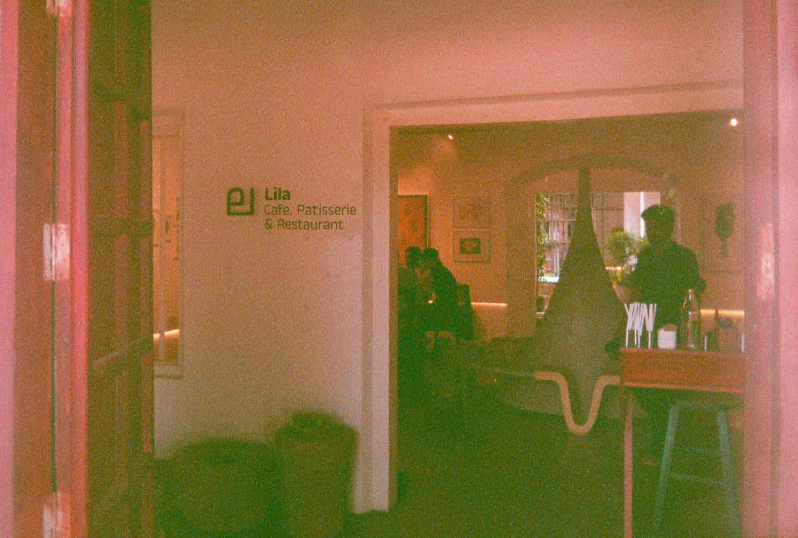 Cafe interior with red light leak — Lila, Fort Kochi
