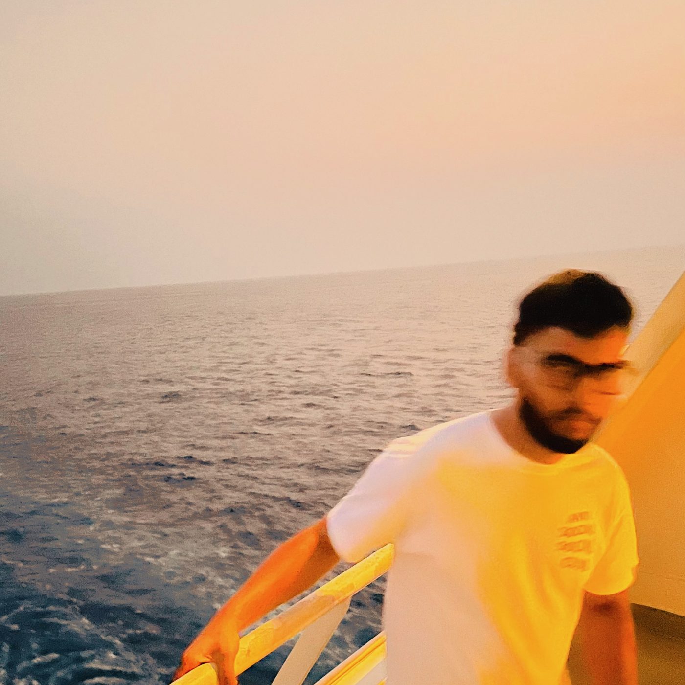 At a railing above the sea at sunset